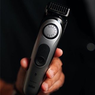 holding an electric shaver in hand